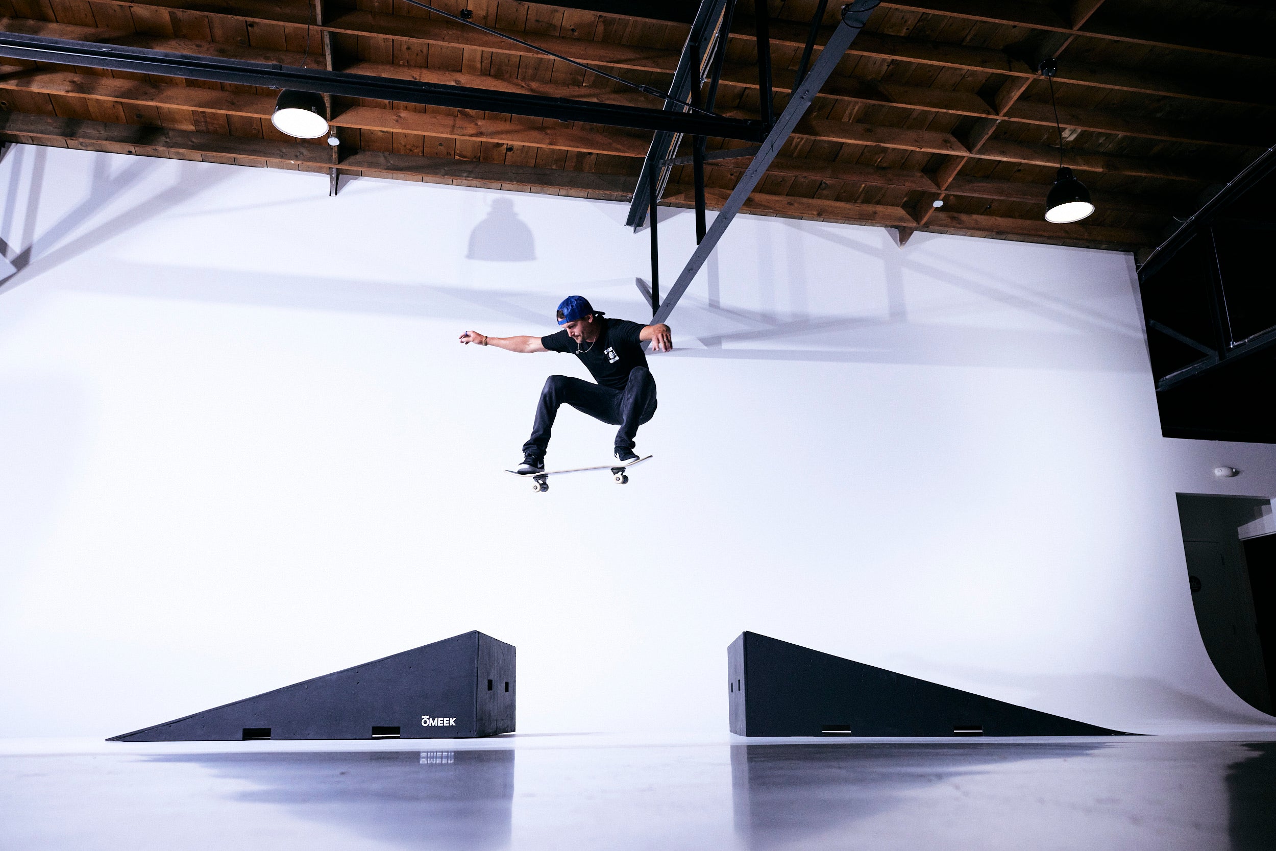 Kam Atwood skating a ramp inside a white studio.