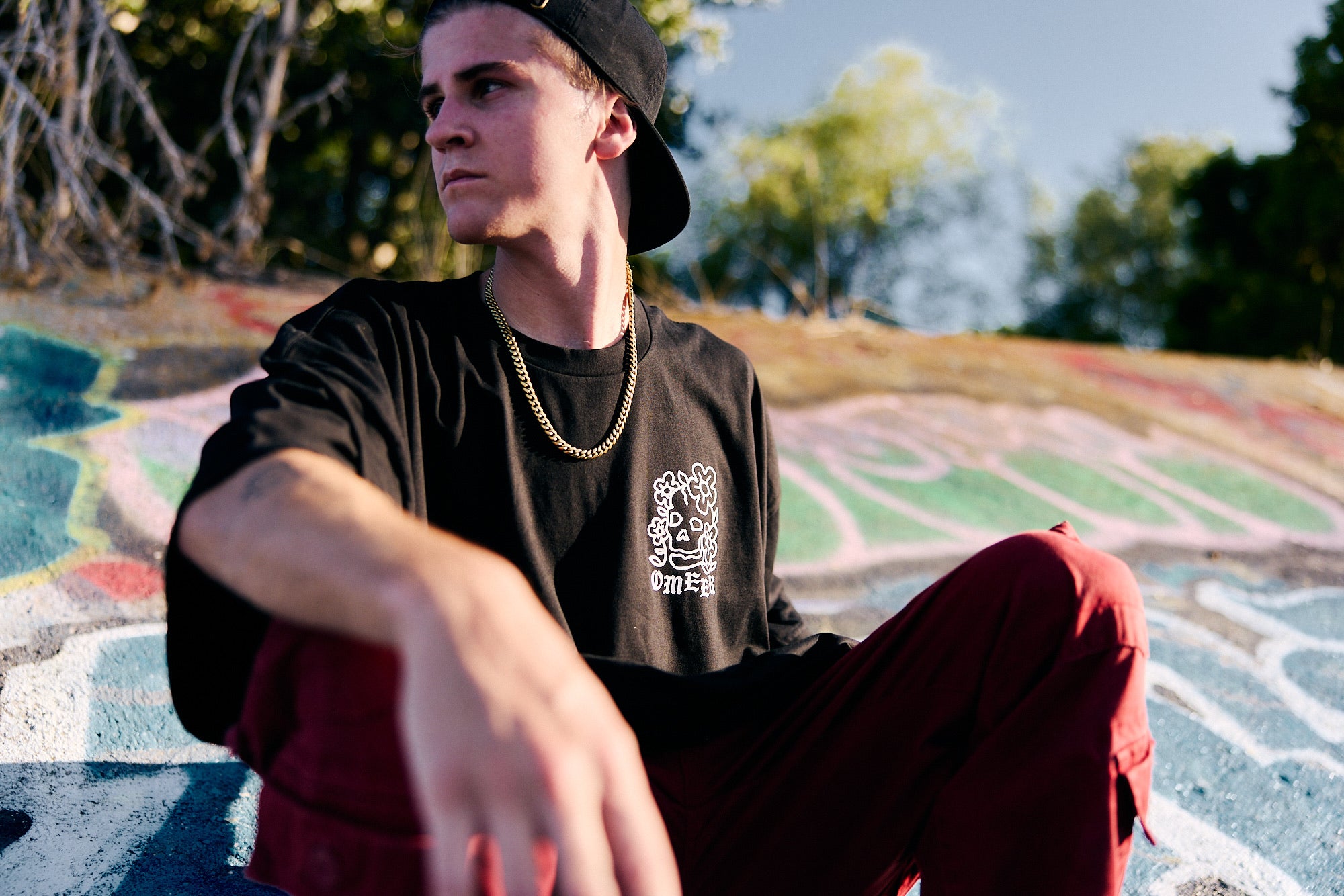 Parker DeMoux sitting in front of a graffiti wall.