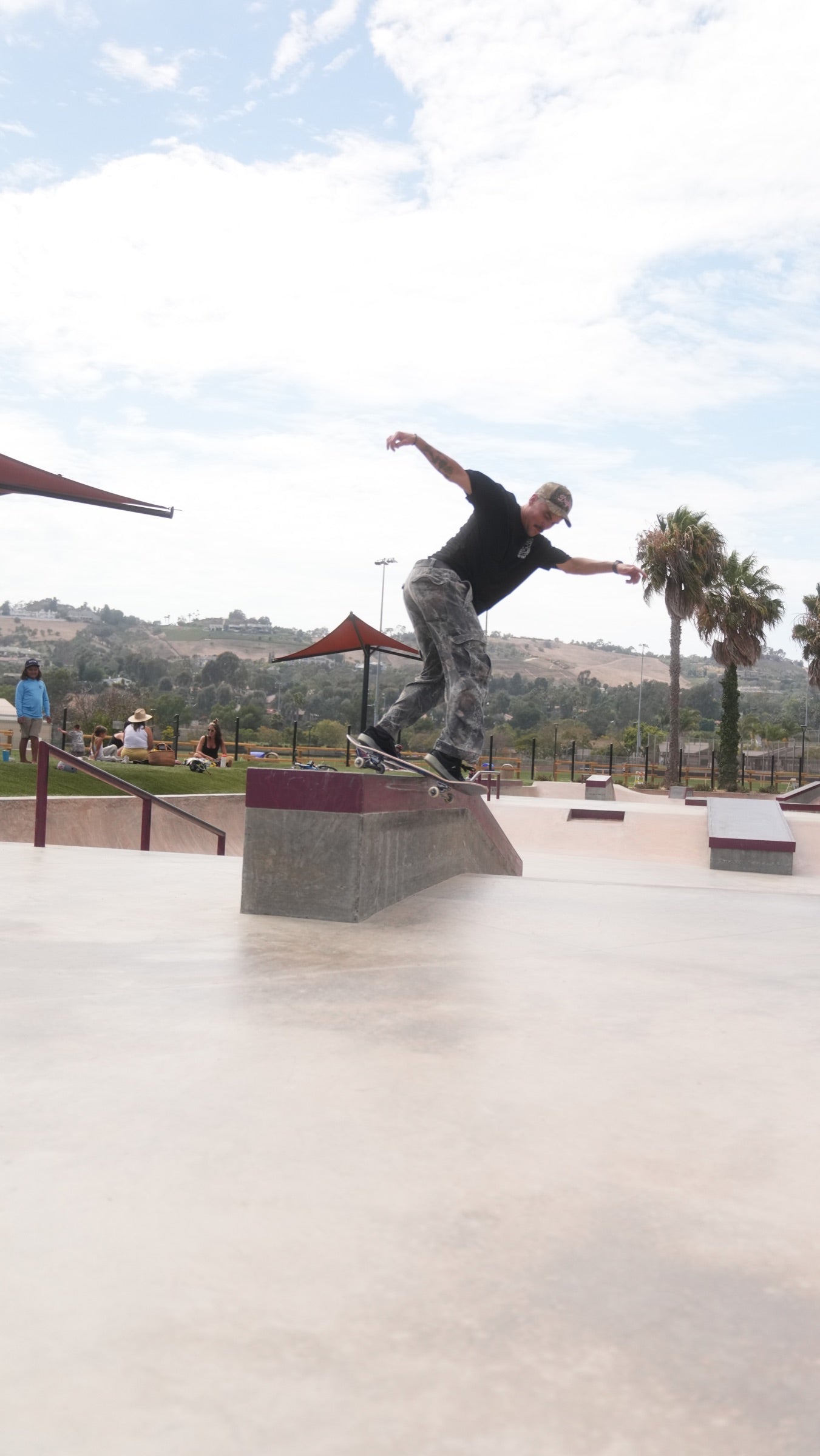 Phil Ceja riding down a skatepark ramp.