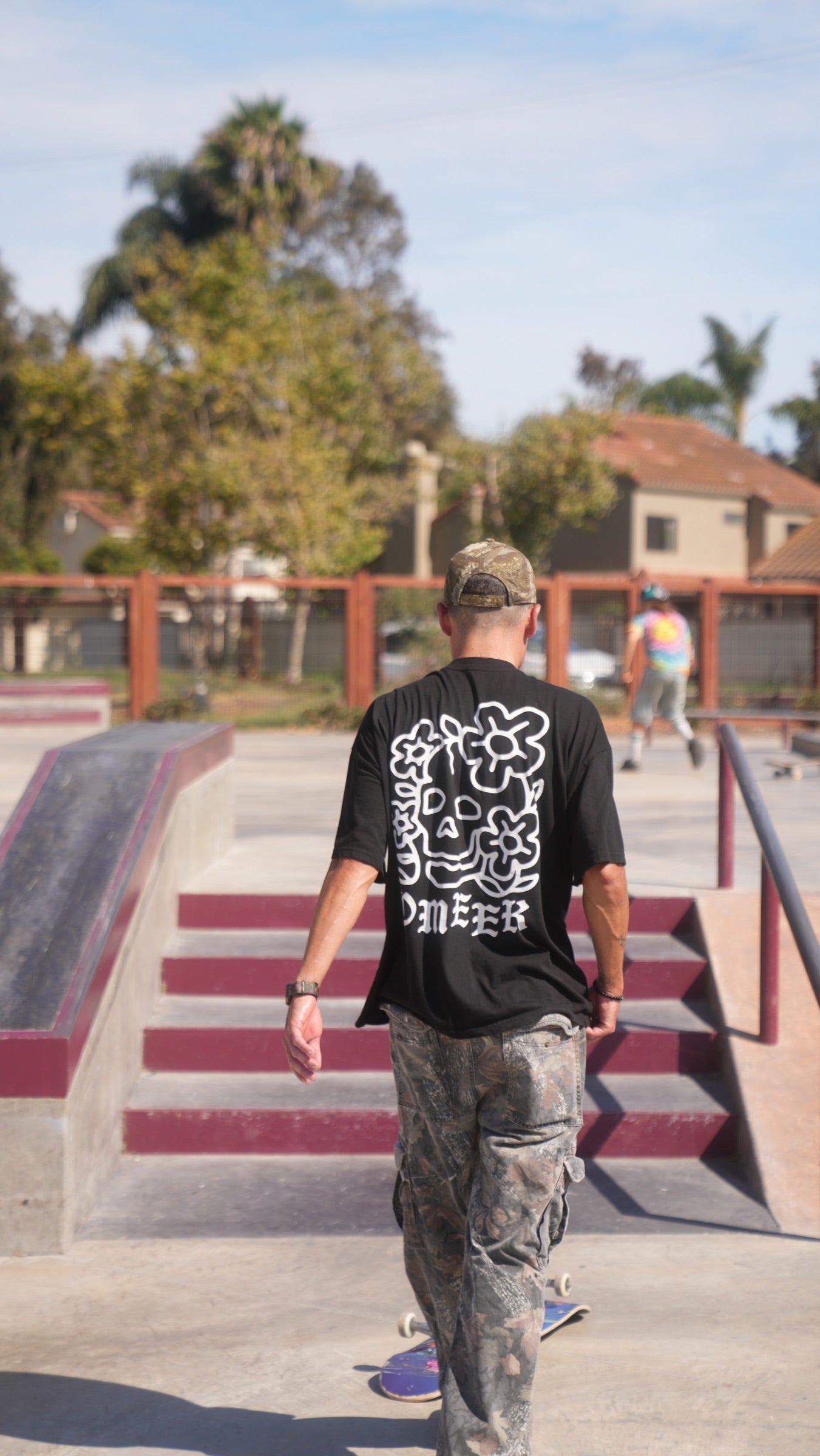 Phil Ceja from behind on a skateboard.