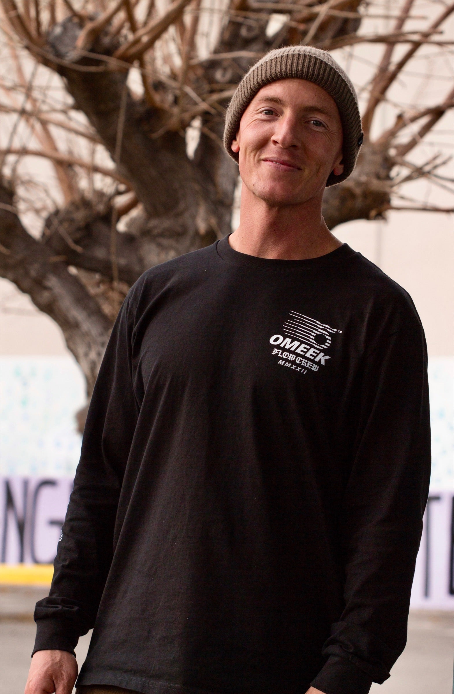 Andy Aced in a beanie and black long sleeve standing outdoors.