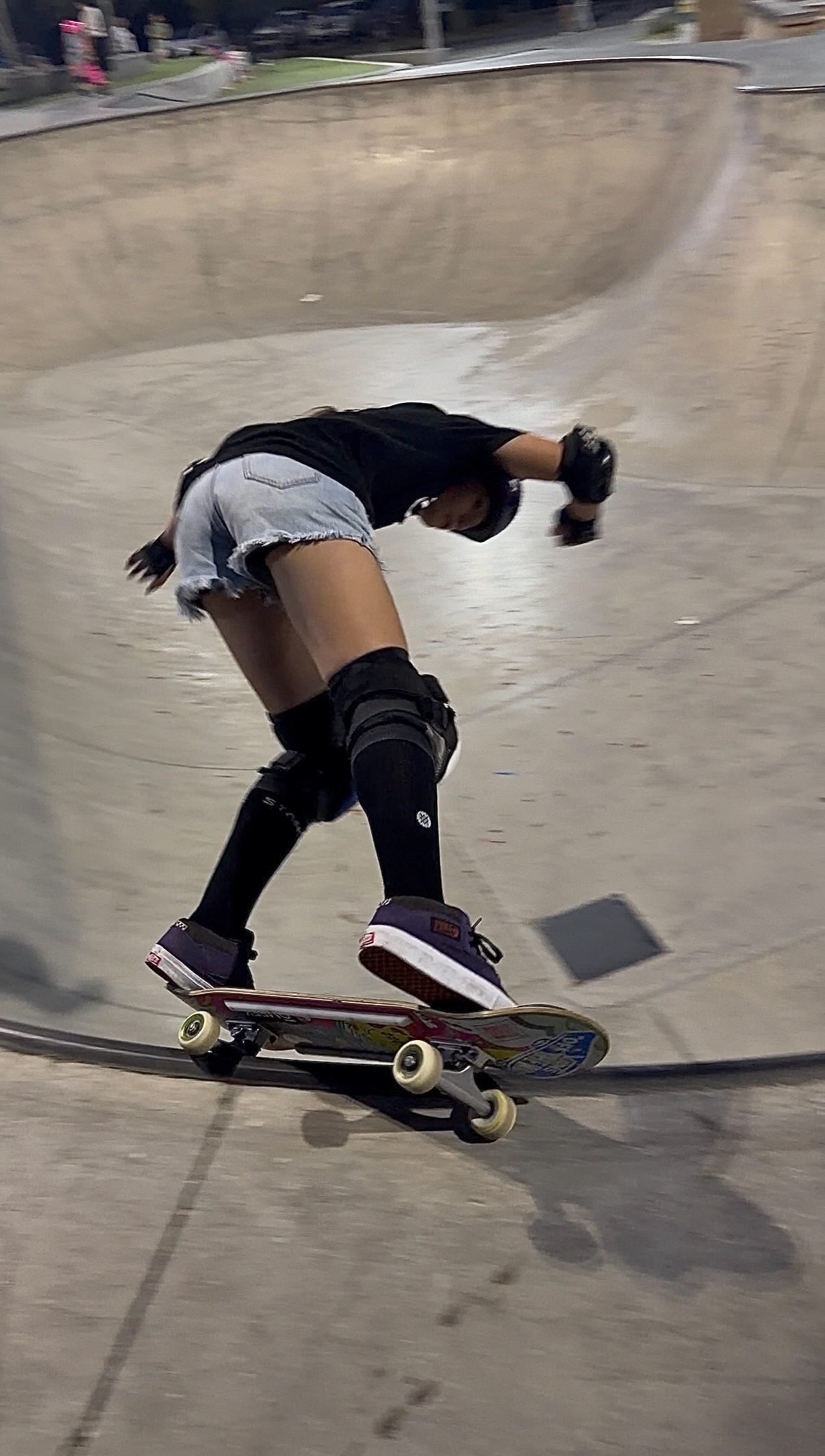 Ivy Raftery in a black shirt and helmet skating a ramp.