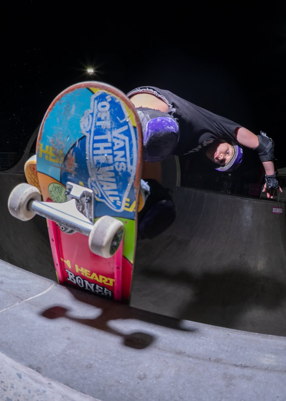 Ivy Raftery in a helmet and pads skating a bowl.