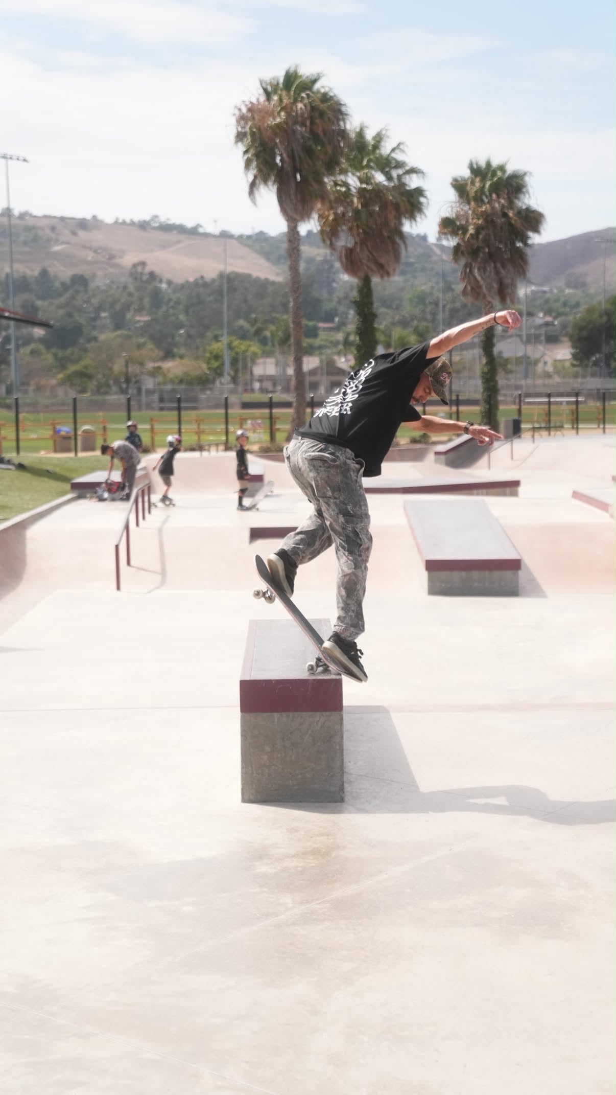 Phil Ceja grinding a ledge at a skatepark.
