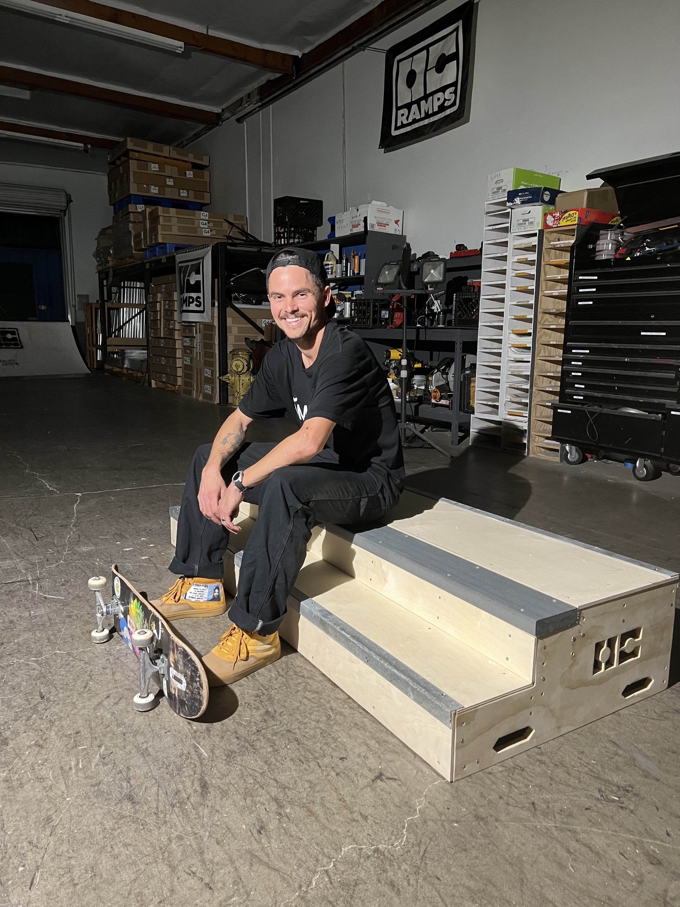 Phil Ceja sitting on a ramp in a workshop.